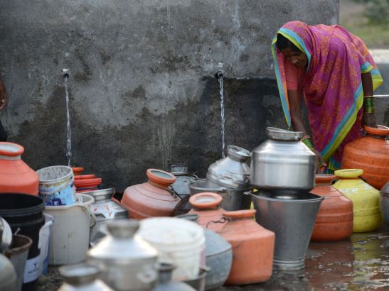 People in the Indian farming village of Dapegaon leave water jugs in line overnight and return at dawn to fill up before the daily supply of water runs out. The village relies on a single well, and shortages have worsened over the past several years as groundwater levels have declined. Image by Steve Elfers. India, 2015. Dapegon
