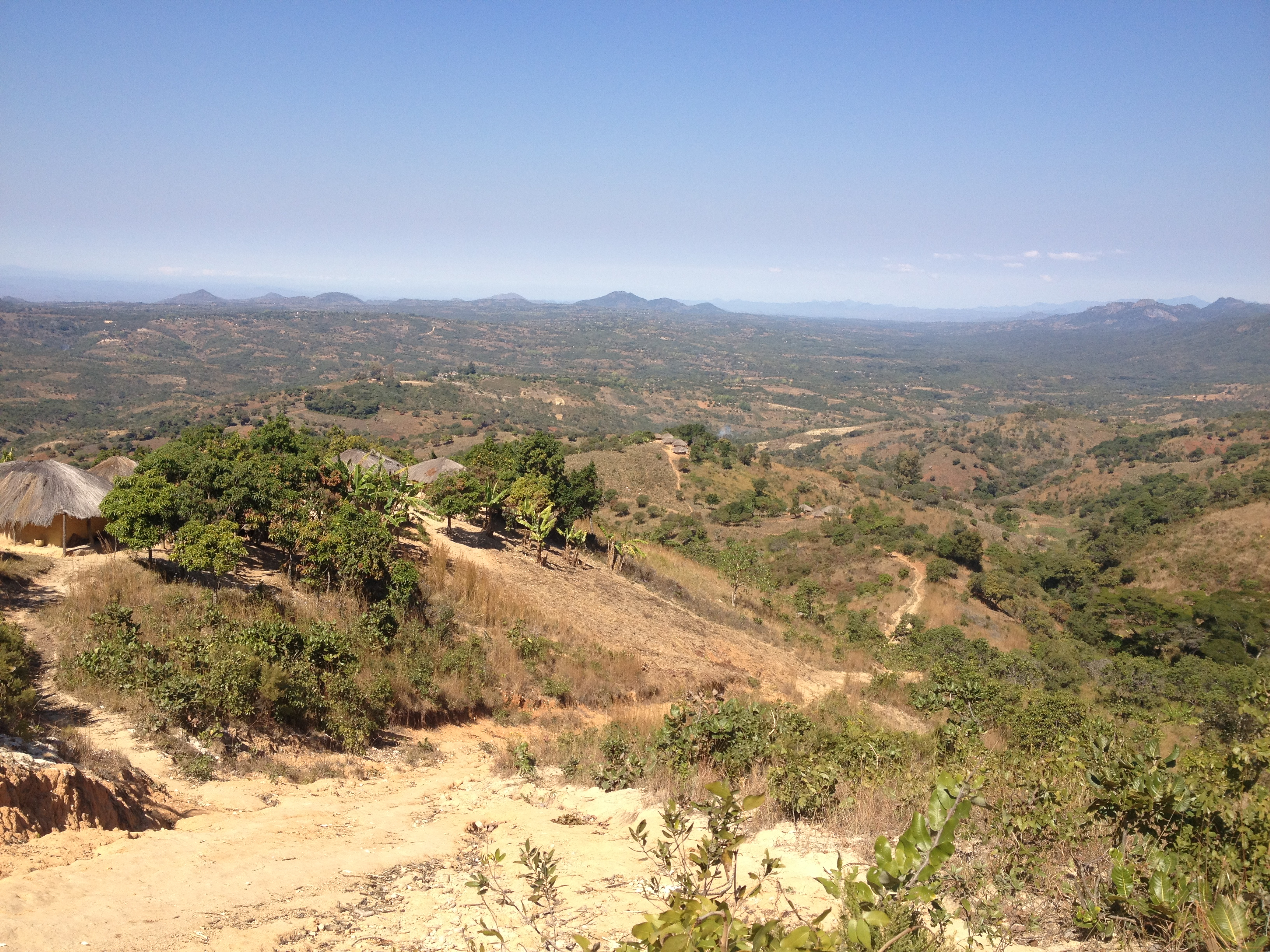 The view on the path from Nsambe to Neno. The government hospital in Neno is not visible, but it sits just in front of the hills in the distance at the center of the photo. With the reintroduction of user fees at Nsambe health center, residents of Nsambe fear they will have to make this journey while sick. Image by Luke Messac. Malawi, 2013. Media file: messac_photo_blog_2.jpg
