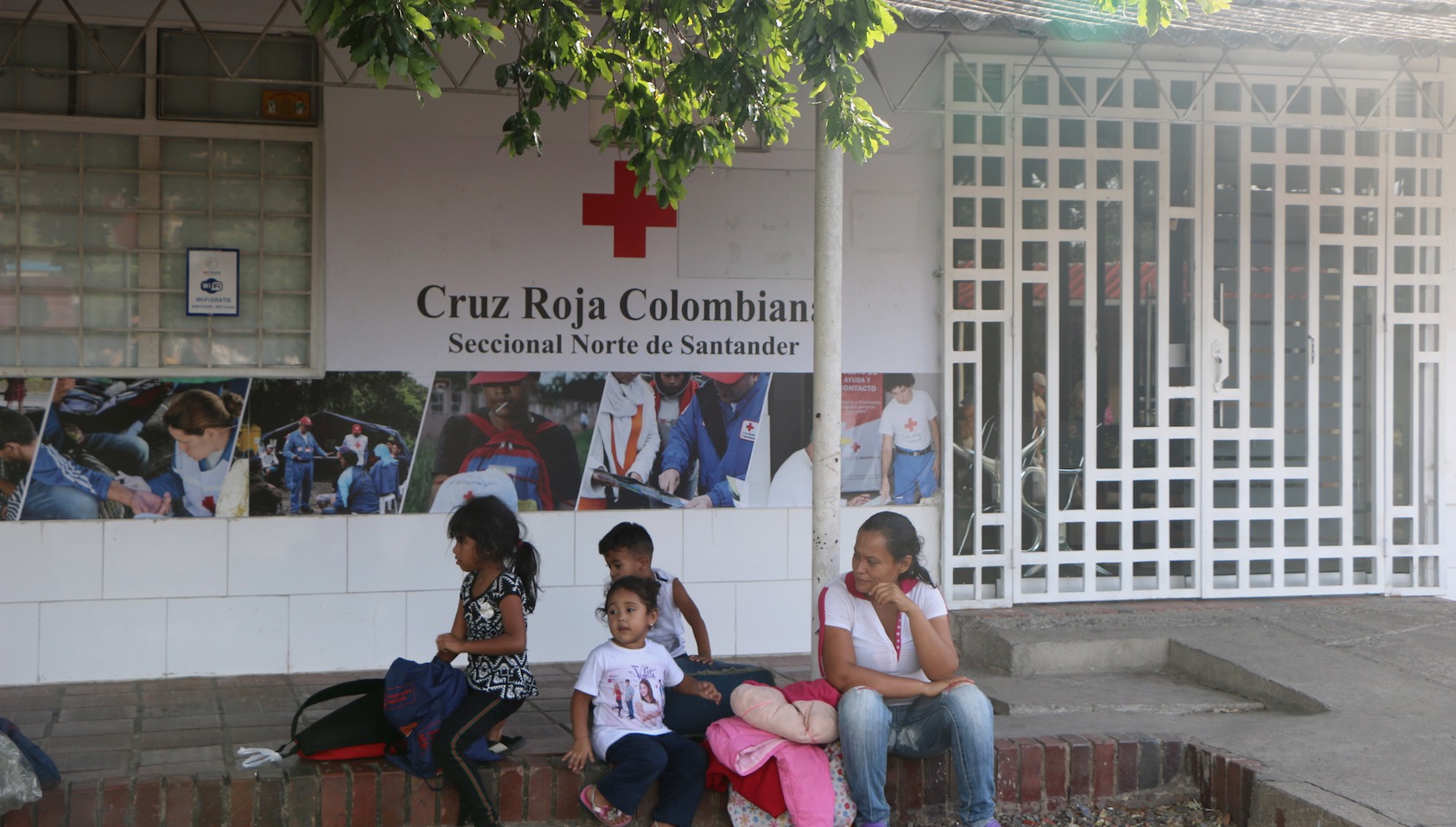 A Venezuelan family waits outside a Red Cross center in Norte de Santander. Image by Patrick Ammerman. Colombia, 2019. A Venezuelan family waits outside a Red Cross center in Norte de Santander. Image by Patrick Ammerman. Colombia, 2019.