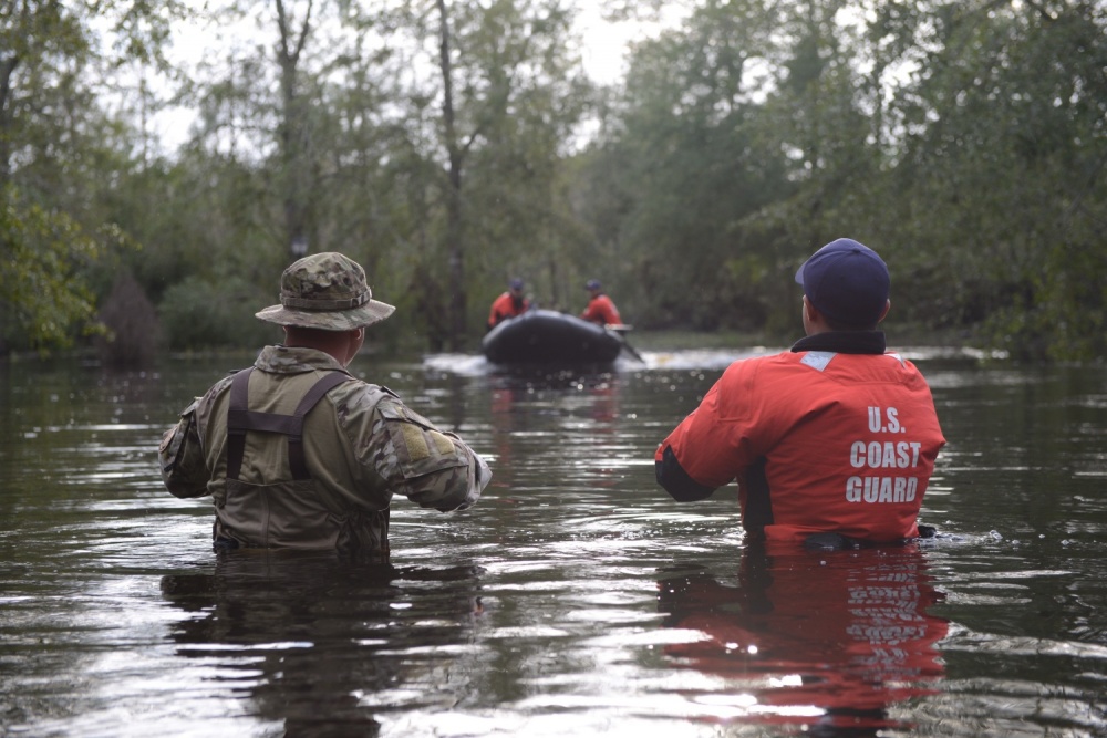Members of Coast Guard Maritime Safety and Security Team Miami and Coast Guard Tactical Law Enforcement Team South wait to be picked up by their rescue team after completing Hurricane Florence search and rescue operations in Brunswick County, September 16, 2018. Image by Petty Officer 3rd Class Trevor Lilburn. United States, 2018. Members of Coast Guard Maritime Safety and Security Team Miami and Coast Guard Tactical Law Enforcement Team South wait to be picked up by their rescue team after completing Hurricane Florence search and rescue operations in Brunswick County, September 16, 2018. Image by Petty Officer 3rd Class Trevor Lilburn. United States, 2018.