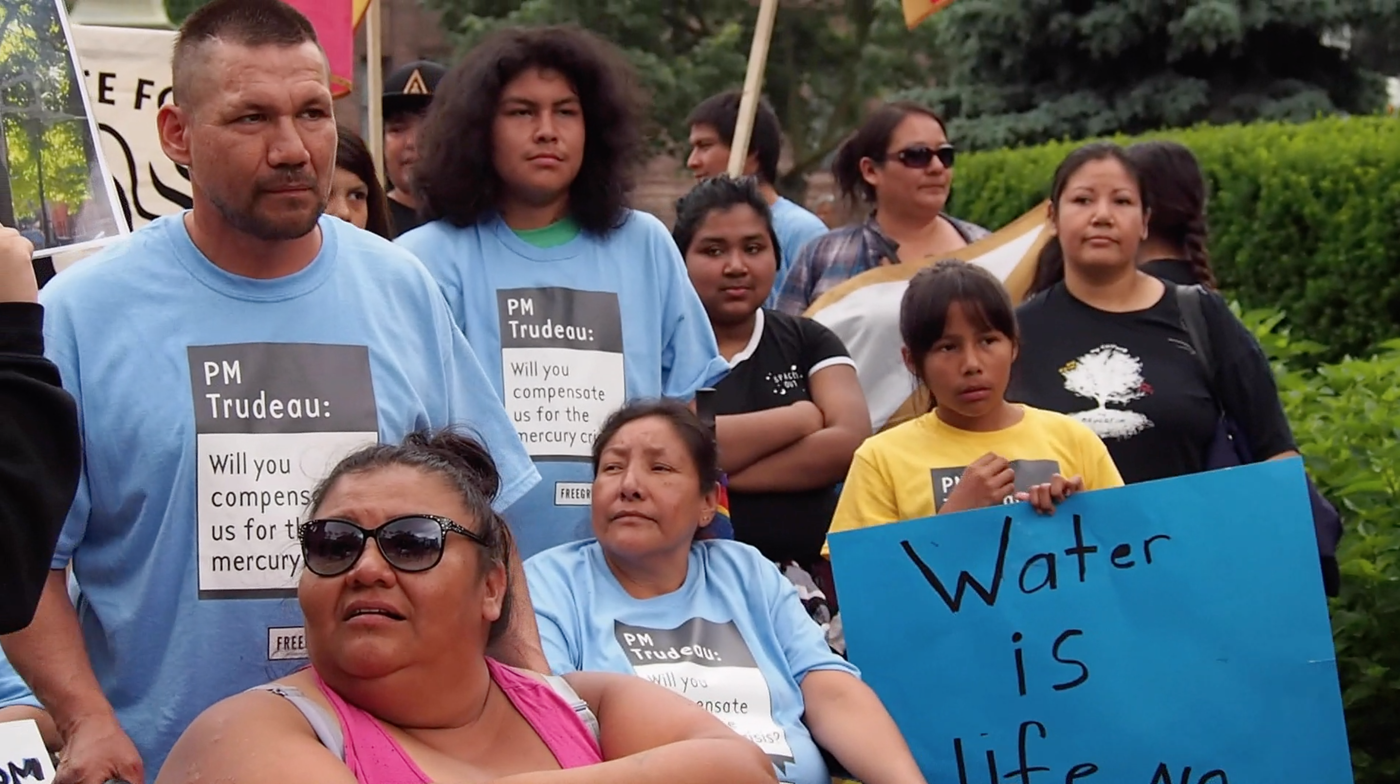 Grassy Narrows community members stand together at their River Run event in Toronto. Image by Shelby Gilson. Canada, 2019. Grassy Narrows community members stand together at their River Run event in Toronto. Image by Shelby Gilson. Canada, 2019.