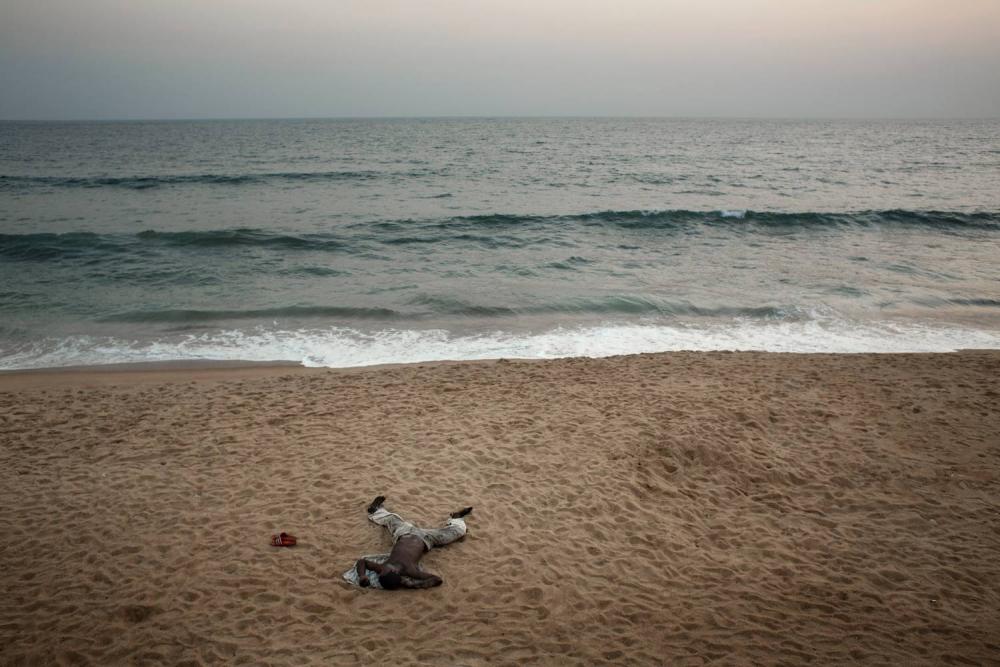 The ocean laps the shore at Trench Town, an informal settlement in Liberia’s capital Monrovia inhabited by mostly ex-combatants of Liberia’s civil wars. Image by Robin Hammond. Liberia, 2013. Media file: hammondliberiapulitzer04.jpg