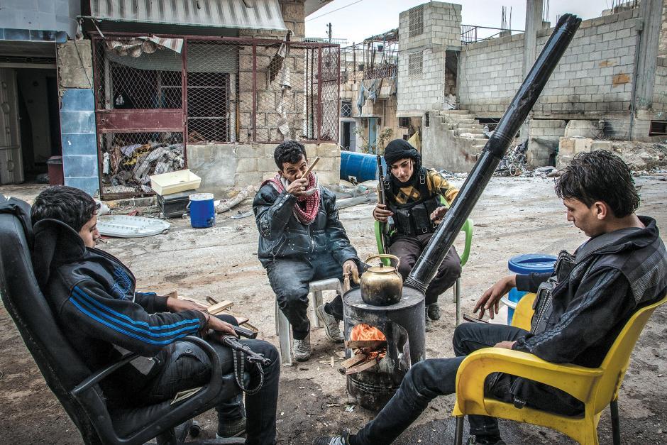 A group of opposition fighters sit around a fire pit in Aleppo. Image by Karam Almasri/Nur. Syria, 2013. Media file: 0814aleppo08.jpg
