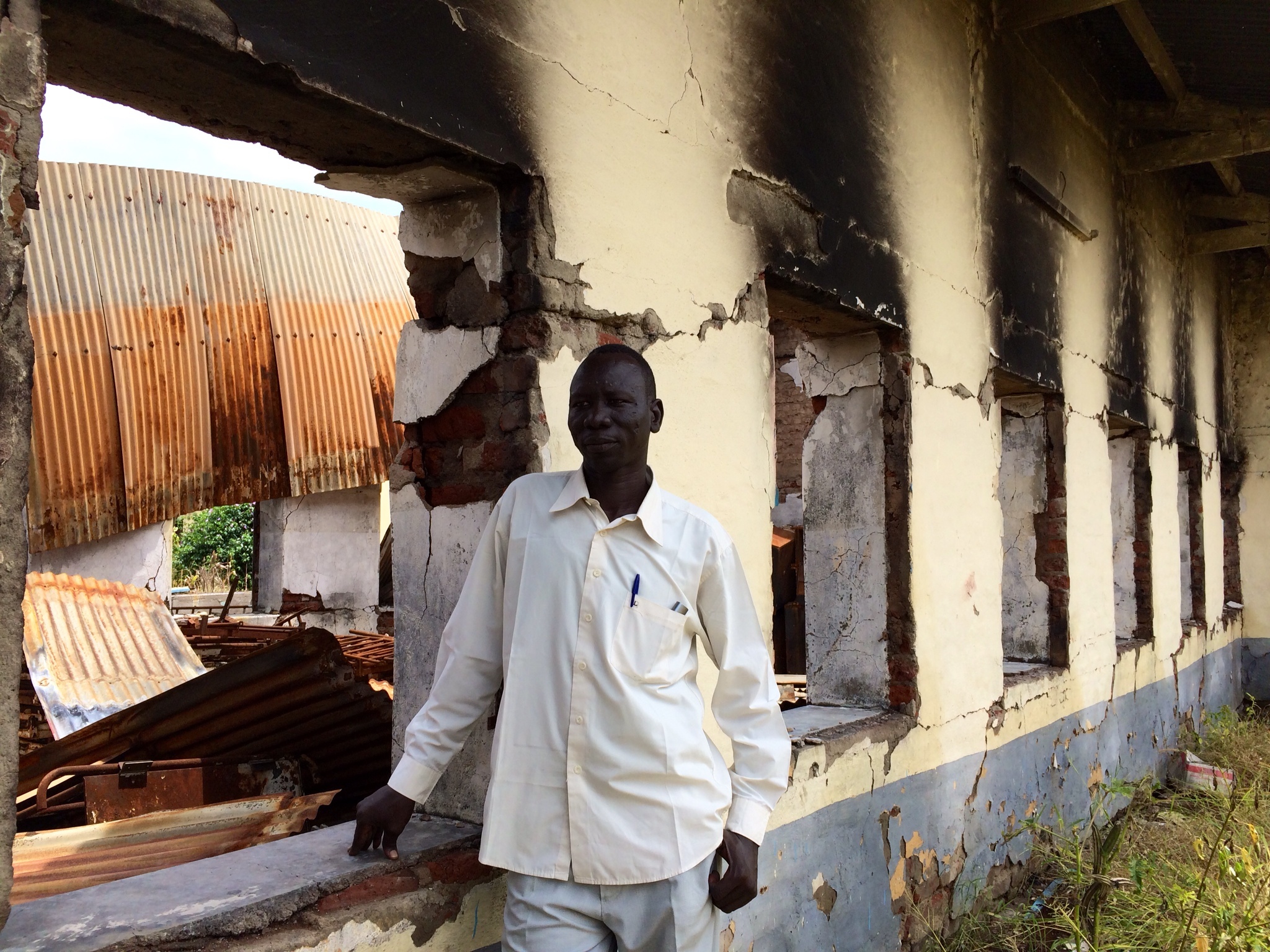 Dr. Olany Alew Akol, the only physician currently working at Malakal Teaching Hispital, leans against the burned-out neonatal ward. Image by Ty McCormick. South Sudan, 2014.