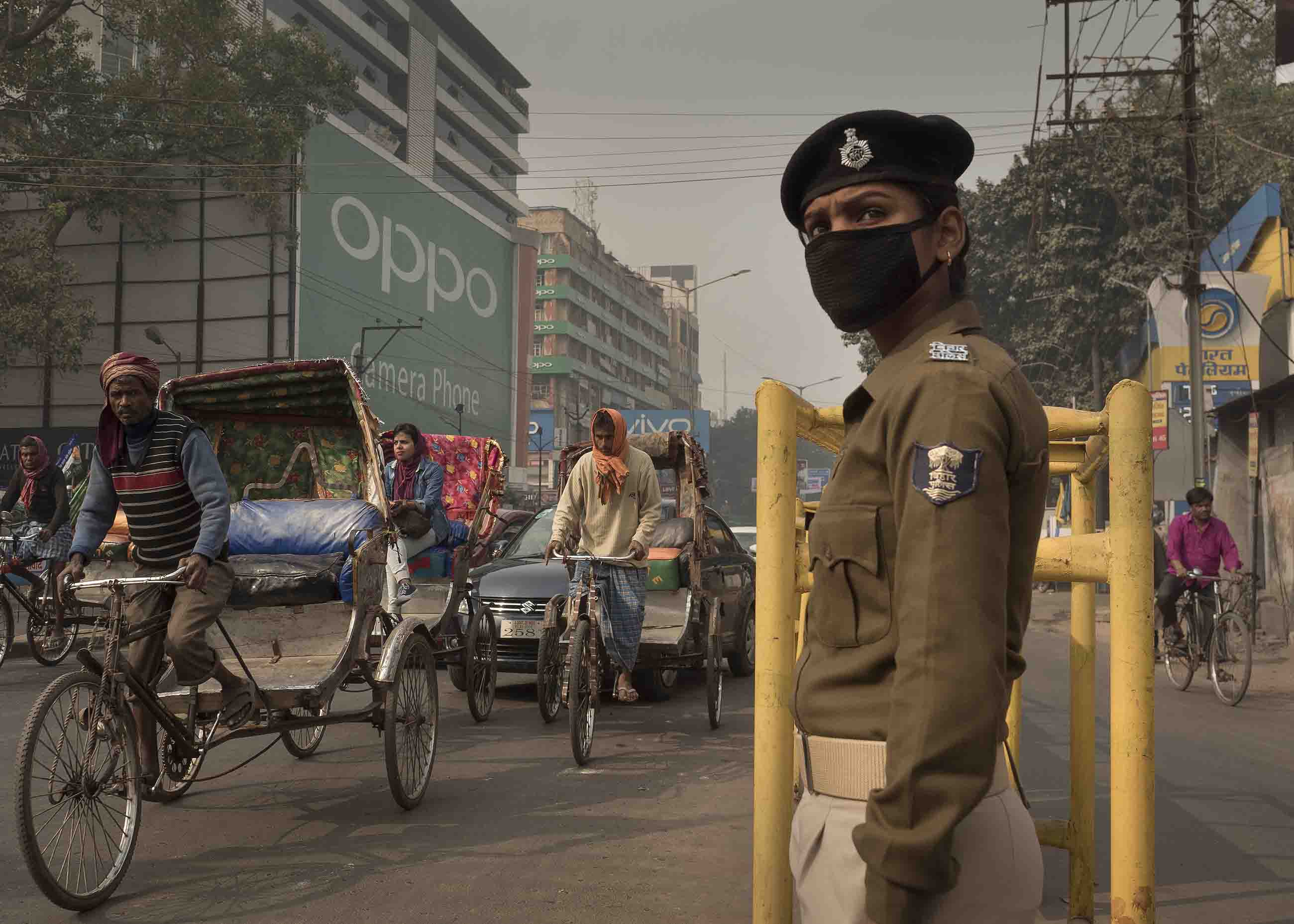 Traffic policewoman Sandhya Bhartj directs traffic in central Patna. Her cloth mask does little to protect her from the smallest particulate pollution. Image by Larry C. Price. India, 2018. Traffic policewoman Sandhya Bhartj directs traffic in central Patna. Her cloth mask does little to protect her from the smallest particulate pollution. Image by Larry C. Price. India, 2018.