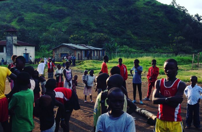 Runners gather early on Sunday morning for a community race at the makeshift soccer field in Kirotshe. Small community races such as this allow the young runners to showcase their hard work and cheer on their teammates. Image by Daniel Socha. Democratic Republic of Congo, 2016. Runners gather