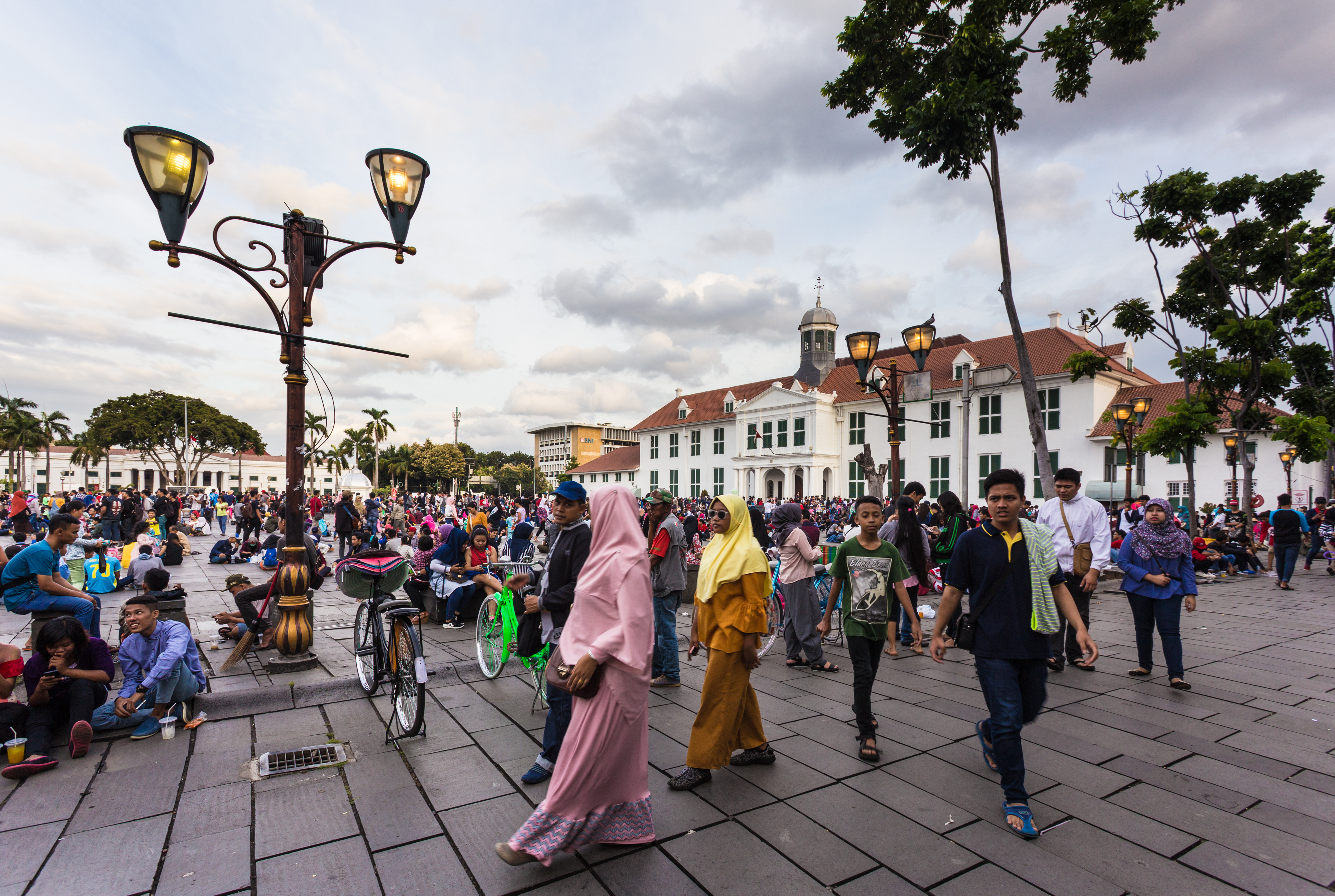 A large crowd of local people spend their Sunday afternoon around the fatahillah Square in Jakarta colonial old town named Kota. Image courtesy of AsiaTravel/Shutterstock. Indonesia, 2017. A large crowd of local people spend their Sunday afternoon around the fatahillah Square in Jakarta colonial old town named Kota. Image courtesy of AsiaTravel/Shutterstock. Indonesia, 2017.
