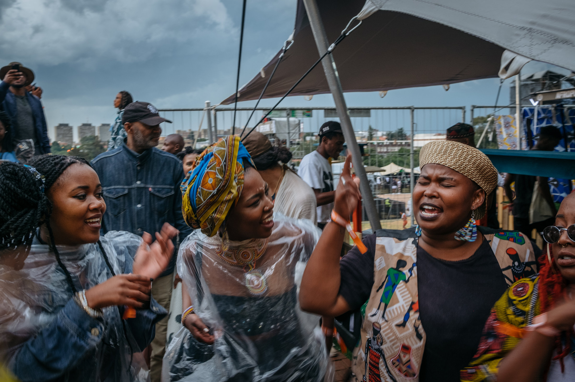 While the Afropunk Joburg festival was on pause because of the weather, crowds make their own music, singing freedom songs. Image by Melissa Bunni Elian. South Africa, 2017. While the Afropunk Joburg festival was on pause because of the weather, crowds make their own music, singing freedom songs. Image by Melissa Bunni Elian. South Africa, 2017.