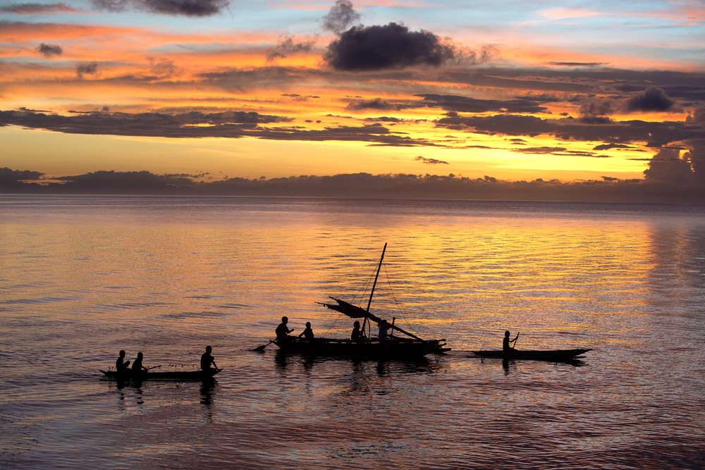 Fishermen gather at sunset in the South Pacific, off Normanby Island in Papua New Guinea. Nearly 1 billion people around the world get the bulk of their animal protein from fish. Image by Steve Ringman. Papua New Guinea, 2013. Media file: st_sea_change.jpg