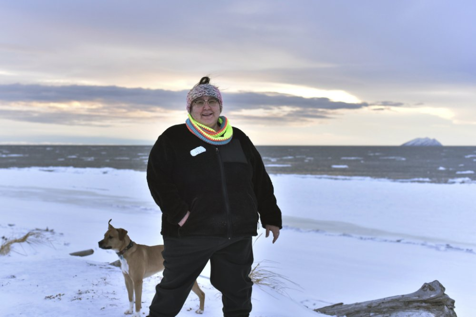 In this Jan. 14, 2019 photo, Clarice "Bun" Hardy stands on the beach with her dog, Marley, in the Native Village of Shaktoolik, Alaska. Hardy, a former 911 dispatcher for the Nome Police Department, says she moved back to her village after a sexual assault left her feeling unsafe in Nome. Image by Wong Maye-E. United States, 2019. In this Jan. 14, 2019 photo, Clarice "Bun" Hardy stands on the beach with her dog, Marley, in the Native Village of Shaktoolik, Alaska. Hardy, a former 911 dispatcher for the Nome Police Department, says she moved back to her village after a sexual assault left her feeling unsafe in Nome. Image by Wong Maye-E. United States, 2019.