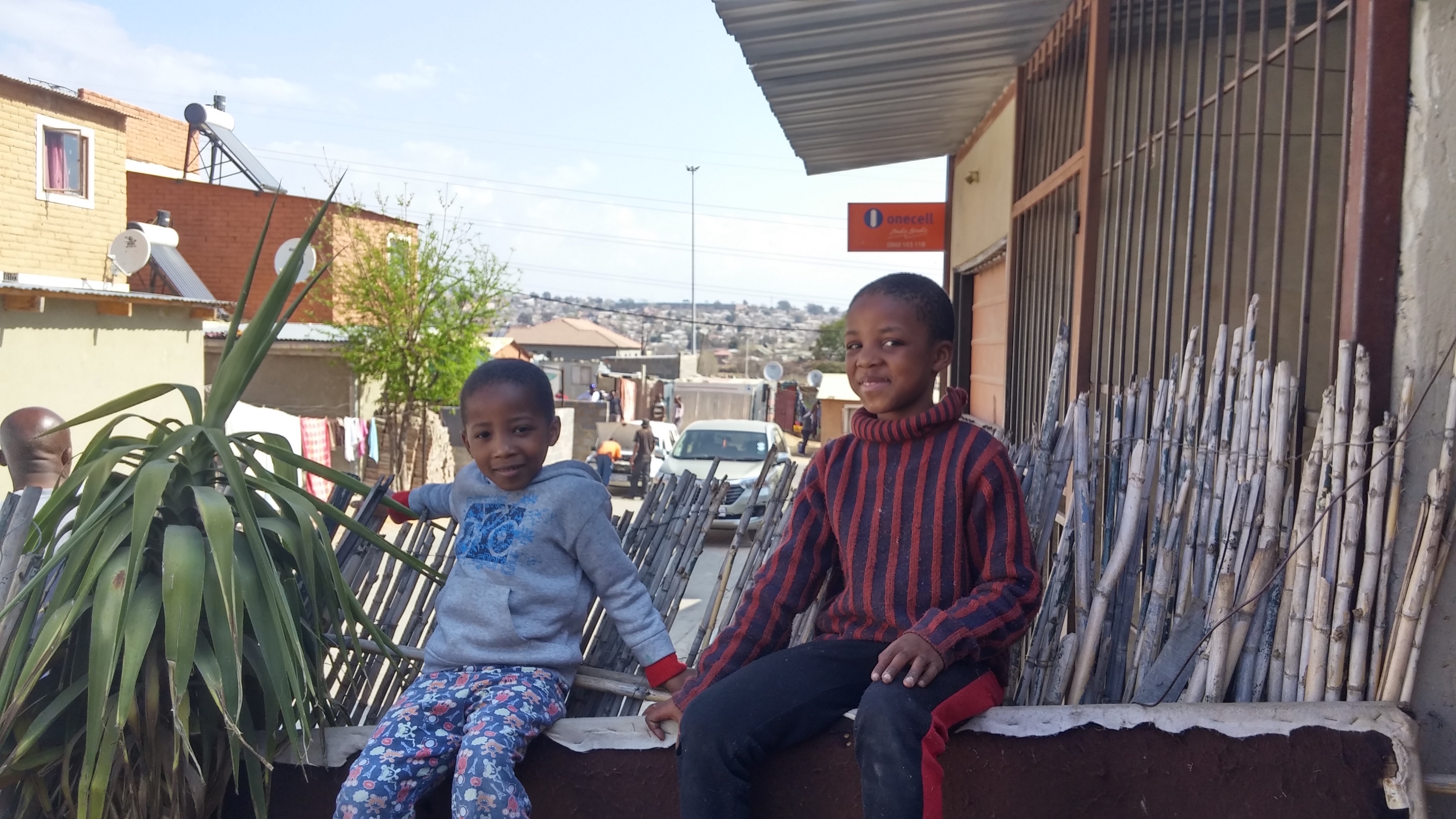 Two of Kgadifele and Banto Mabasa's three sons, all of whom live in a two-room house as tenants in Extension 9, a government development on Alex's East Bank. Kgadifele Mabasa says that they were promised a bigger home a couple of years after they moved into the settlement in 2010, but that nothing has happened since then. Image by Christian Belanger. South Africa, 2016. Media file: 20160820_140124_hdr_copy.jpg