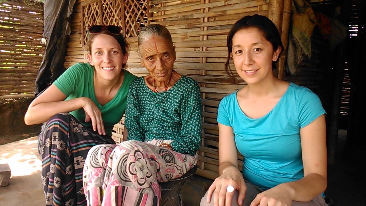 Julia Rendleman (left) and Moriah Balingit (right) visit with Purnawati Timsina at her hut in the refugee camp.