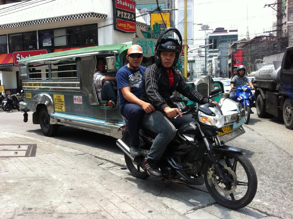 A small motorcycle and a “jeepney” minibus — the twin terrors of Manila roads. Image by Tom Hundley. Philippines, 2013. Image by Tom Hundley. Philippines, 2013.