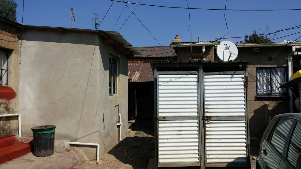 A property in Old Alex, the densest part of Alexandra township, where up to a dozen families will sometimes live in a backyard together. Rosaline Selepe, who has lived in the house on the left since 1980, says that though she would like to expand her property, she has no space to do so. Image by Christian Belanger. South Africa, 2016. A property in Old Alex, the densest part of Alexandra township