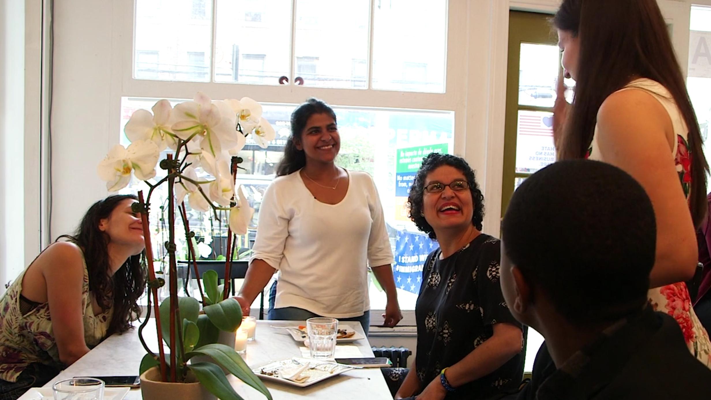 Adwa, a refugee, Kerry, founder of the Brooklyn cafe, and others celebrate at the Emma's Torch graduation ceremony. Image by Thea Piltzecker. New York City, 2018. Adwa, a refugee, Kerry, founder of the Brooklyn cafe, and others celebrate at the Emma's Torch graduation ceremony. Image by Thea Piltzecker. New York City, 2018.