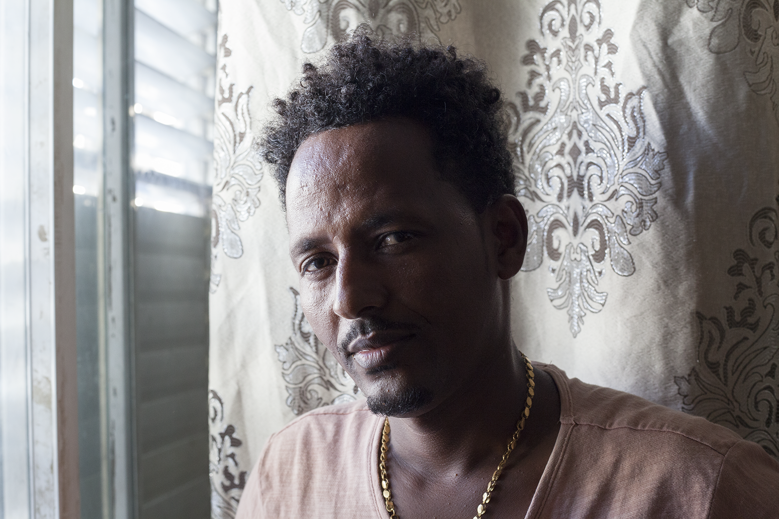Mesgena (who chose to withhold his last name for privacy reasons), was an asylum seeker from Eritrea living with his wife and four small children in a one bedroom apartment in Tel Aviv. A victim of torture when crossing the Sinai to reach Israel, he was able to receive refugee status in Canada. He and his family were relocated to Toronto in late July. Image by Caron Creighton. Israel, 2018. Mesgena (who chose to withhold his last name for privacy reasons), was an asylum seeker from Eritrea living with his wife and four small children in a one bedroom apartment in Tel Aviv. A victim of torture when crossing the Sinai to reach Israel, he was able to receive refugee status in Canada. He and his family were relocated to Toronto in late July. Image by Caron Creighton. Israel, 2018.