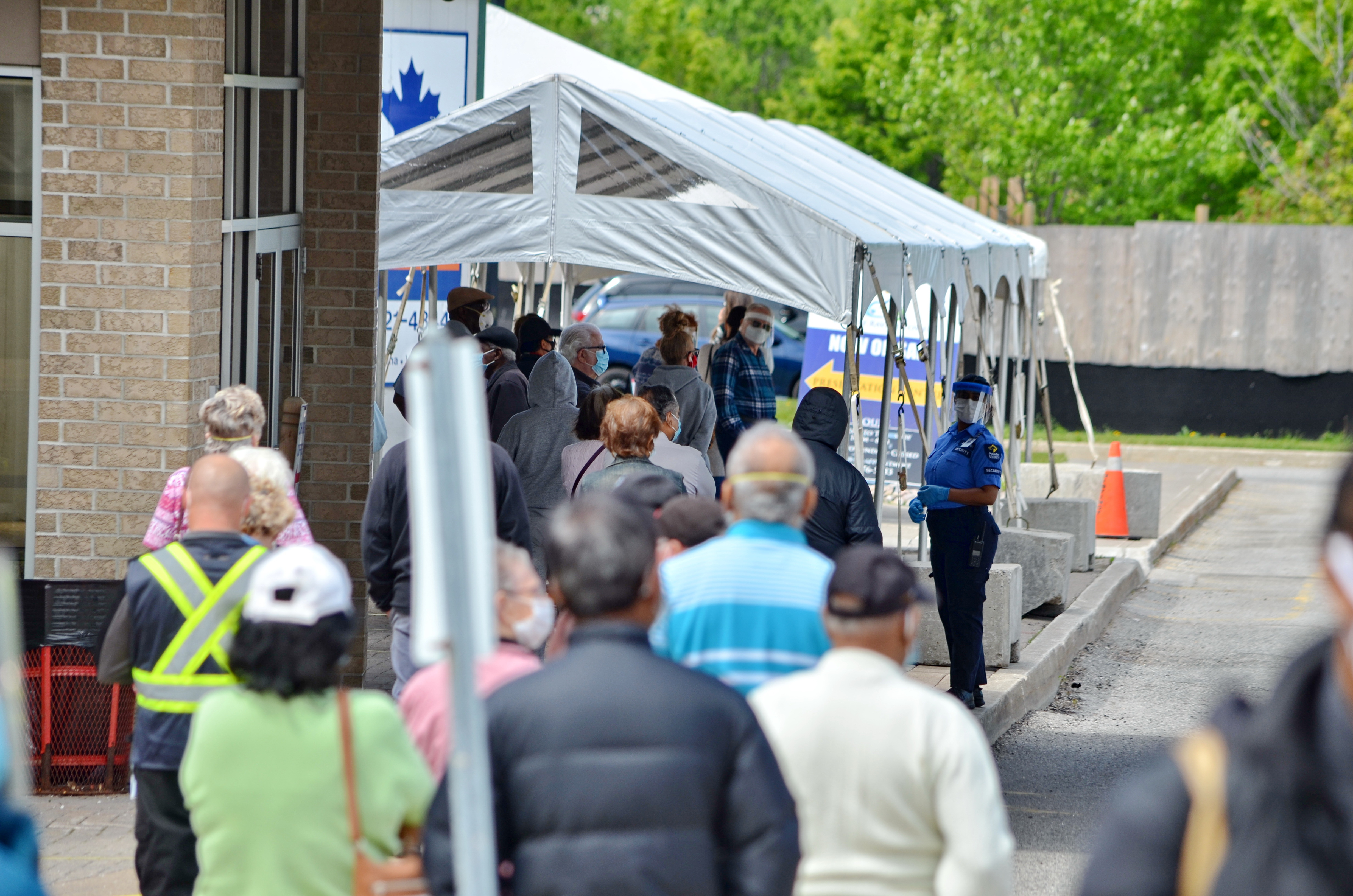 People wait in line for a COVID-19 test at a pop-up mobile Assessment Centre. Image by Bob Hilscher/Shutterstock. Canada, 2020. People wait in line for a COVID-19 test at a pop-up mobile Assessment Centre. Image by Bob Hilscher/Shutterstock. Canada, 2020.