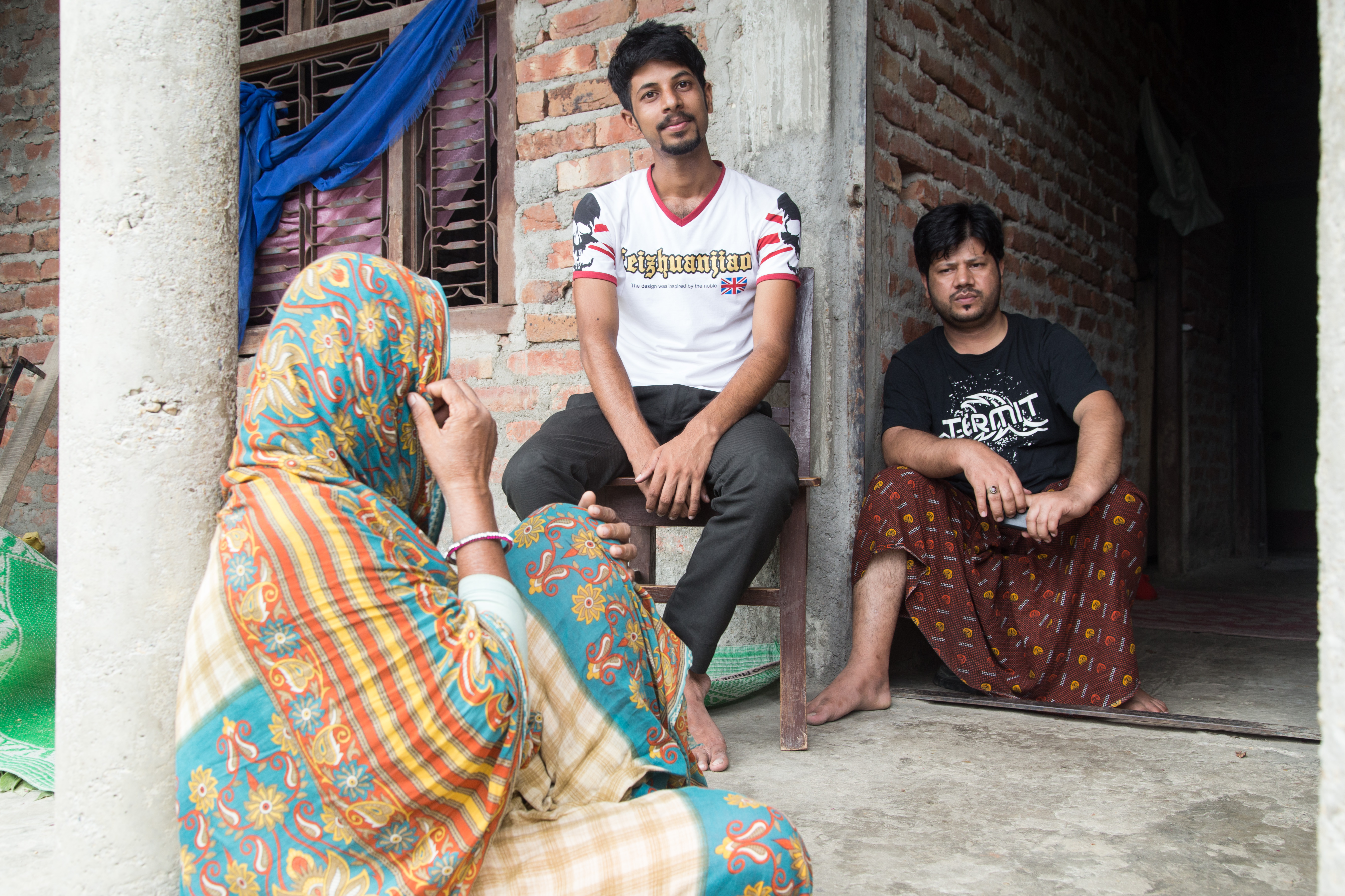 Mohammad Alladin Ali, center, talks about his aspirations in life while discussing his plans to migrate to Qatar as his mother, Mariam Khatun, and his eldest brother, Mumtaz Safi, who recently returned to Nepal from Qatar, listen. Image by Pankaj Khadka. Nepal, 2015. Media file: time_to_leave-1.jpg