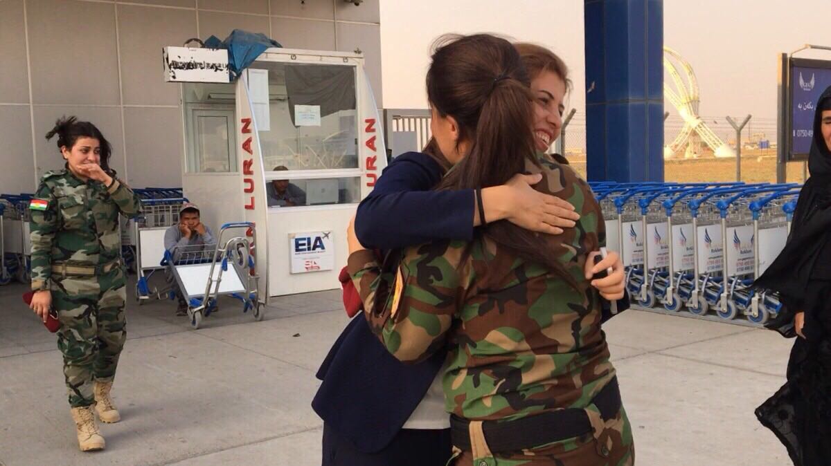 Lieutenant Kochar Saleh Haji, outside the Erbil International Airport, embraces a fighter from her peshmerga unit. Image by Kenneth Rosen. Iraq, 2017. Lieutenant Kochar Saleh Haji, outside the Erbil International Airport, embraces a fighter from her peshmerga unit. Image by Kenneth Rosen. Iraq, 2017.