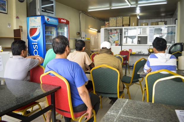Nepalese migrant workers sit in a Nepalese restaurant near a labor camp north of Doha, Qatar. Image by Yam Kumari Kandel. Qatar, 2016.