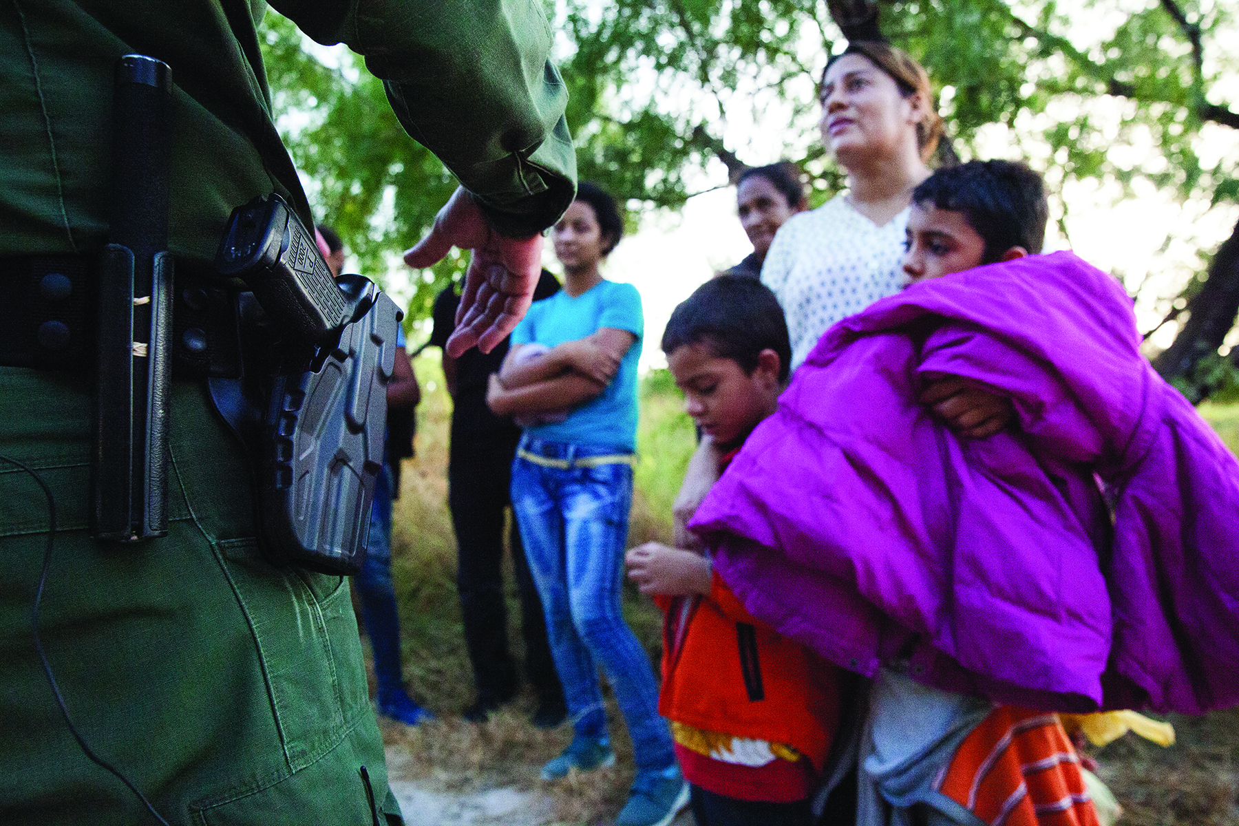 Border Patrol agents apprehend a group of migrants from Honduras at the southern border. Image by Jinitzail Hernández. United States, 2019. Border Patrol agents apprehend a group of migrants from Honduras at the southern border. Image by Jinitzail Hernández. United States, 2019.