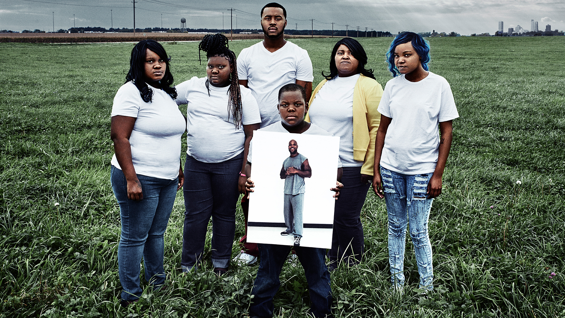 The Walker family poses with a photo of their incarcerated father and husband, Baron, in a still from Milwaukee 53206. Image courtesy of Transform Films. United States, 2016. The Walker family poses with a photo of their incarcerated father and husband, Baron, in a still from Milwaukee 53206. Image courtesy of Transform Films. United States, 2016.