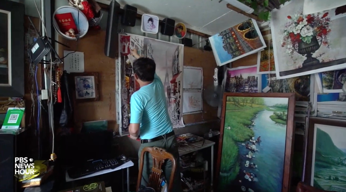 Artist Zeng Muquan has never set foot outside China, but he's painted tens of thousands of European scenes from his studio in the country's southern Guangdong province. Image by PBS NewsHour. China, 2019. Artist Zeng Muquan has never set foot outside China, but he's painted tens of thousands of European scenes from his studio in the country's southern Guangdong province. Image by PBS NewsHour. China, 2019.