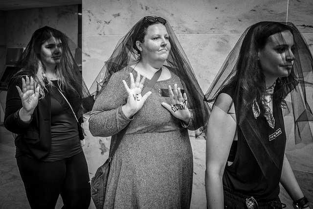 Women, many wearing black veils protesting the nomination of Brett Kavanaugh to the U.S. Supreme Court at the Hart Senate Office Building on Friday, September 7. Image by Phil Roeder. Washington D.C., 2018. (CC BY 2.0) Women, many wearing black veils protesting the nomination of Brett Kavanaugh to the U.S. Supreme Court at the Hart Senate Office Building on Friday, September 7. Image by Phil Roeder. Washington D.C., 2018. (CC BY 2.0)