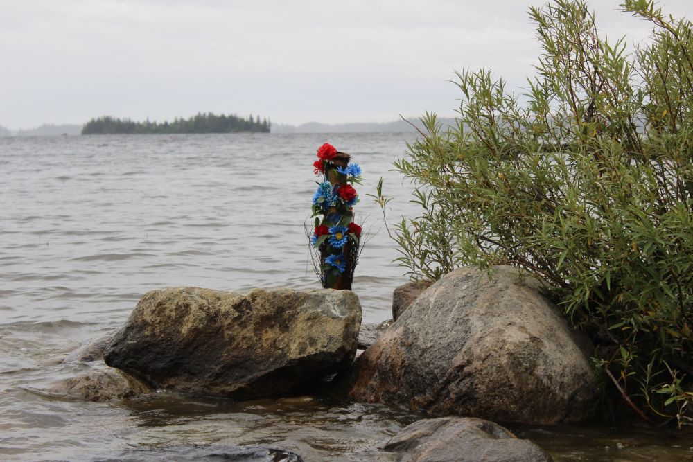 Following the departure of the archbishops, a flower arrangement is placed on the rocks. Floral displays accompany many religious ceremonies and rites. Image by Dillon DeWitt. Canada, 2016. Following the departure of the archbishops, a flower arrangement is placed on the rocks. Floral displays accompany many religious ceremonies and rites