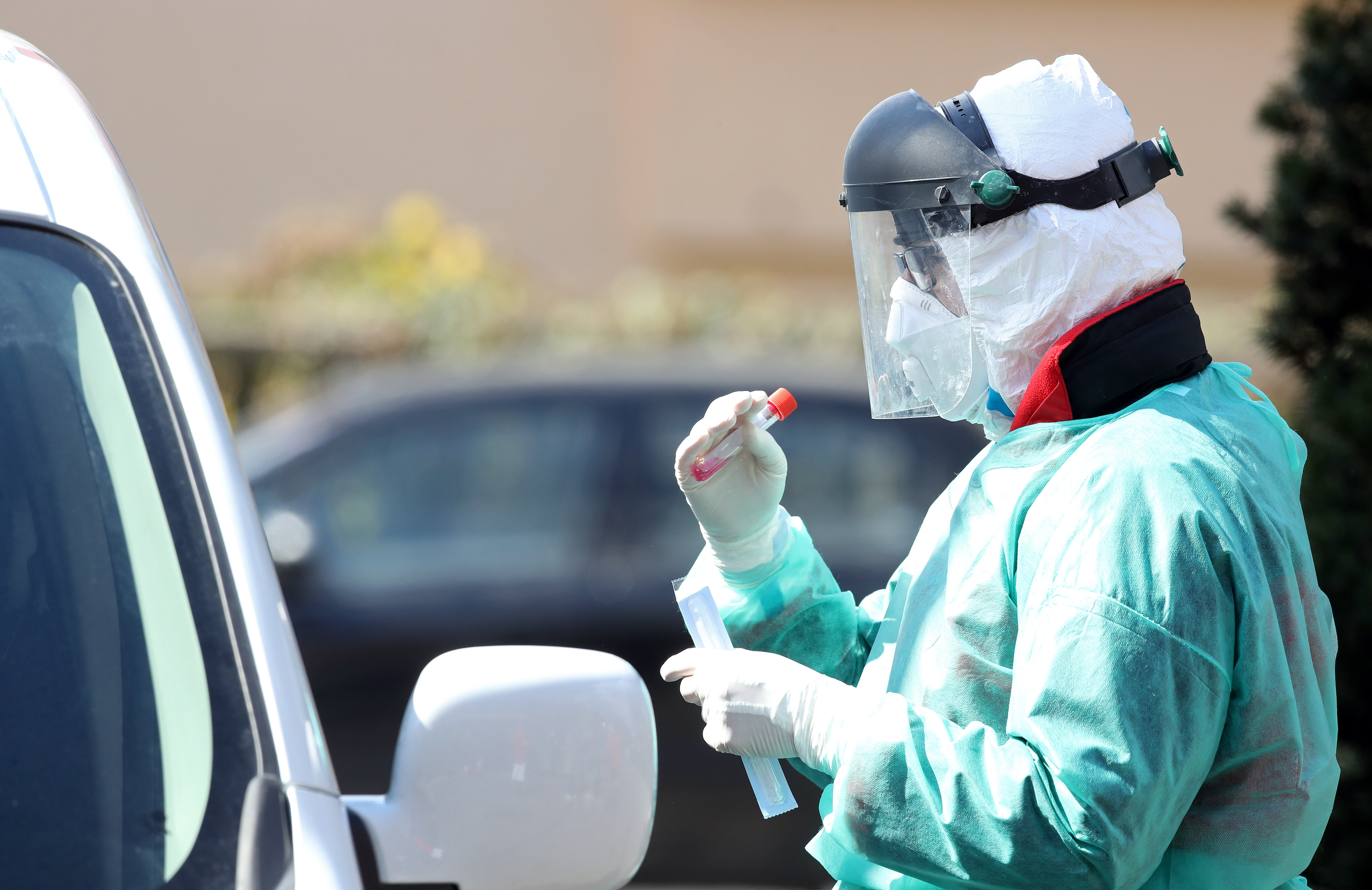 Medical staff member performs coronavirus tests at drive-thru testing point. Image by Damir Sencar / Shutterstock. Croatia, 2020. Medical staff member performs coronavirus tests at drive-thru testing point. Image by Damir Sencar / Shutterstock. Croatia, 2020.