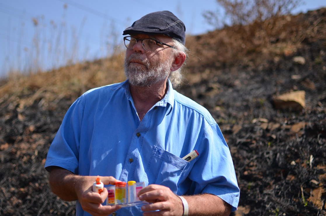 David van Wyk tests water quality in streams near piles of mine waste in Riverlea. Image by Mark Olalde. South Africa, 2016. David van Wyk tests water quality in streams near piles of mine waste in Riverlea. Image by Mark Olalde. South Africa, 2016.