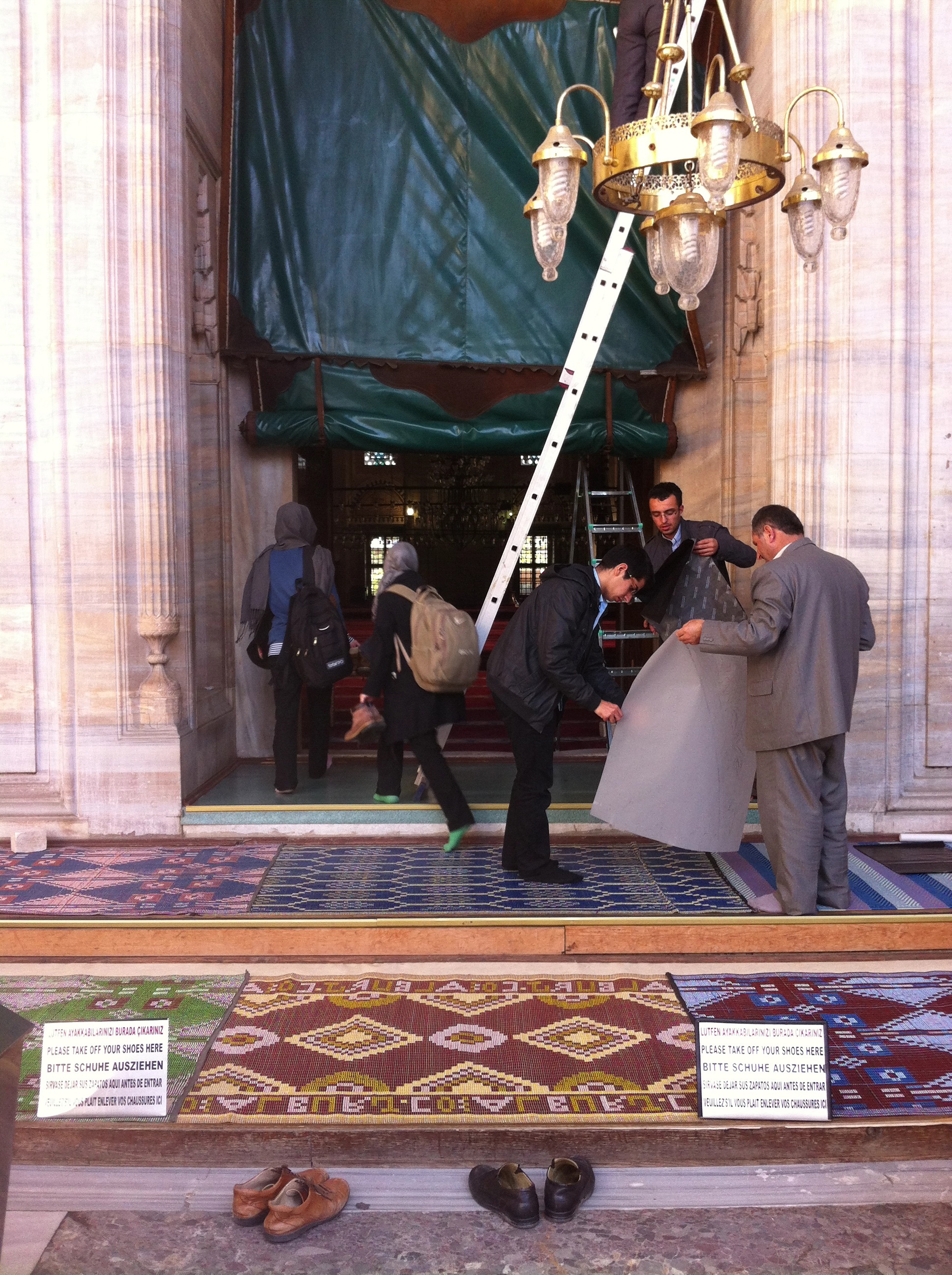Young women break for prayer and dodge a maintenance team, in one of Fatih's many mosques. Image by Jenna Krajeski. Turkey, 2013. Media file: img_0897.jpg