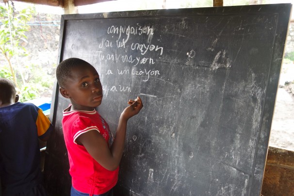 Marceline Bauma, 8, lives in Goma, Congo. Some of Marceline’s life in that African city is far different than life in the United States. Her home has no electricity or running water. But other parts are familiar: There’s schoolwork to do, and her help is needed around the house. Image by Kem Knapp Sawyer. Congo, 2013. Media file: marcelineboard.jpg
