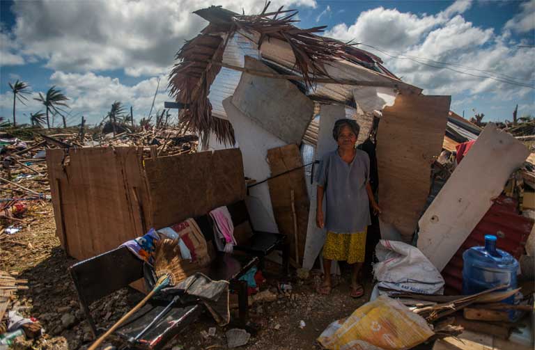 Super Typhoon Haiyan. A woman stands outside her makeshift shack in the storm’s aftermath. We “must integrate questions of justice in debates on the environment, so as to hear the cry of the earth and the cry of the poor,” wrote Pope Francis in his encyclical. Image by Mass Communication Specialist Seaman Liam Kennedy courtesy of the U.S. Navy. Philippines, 2013. Media file: bishops_photo.jpg