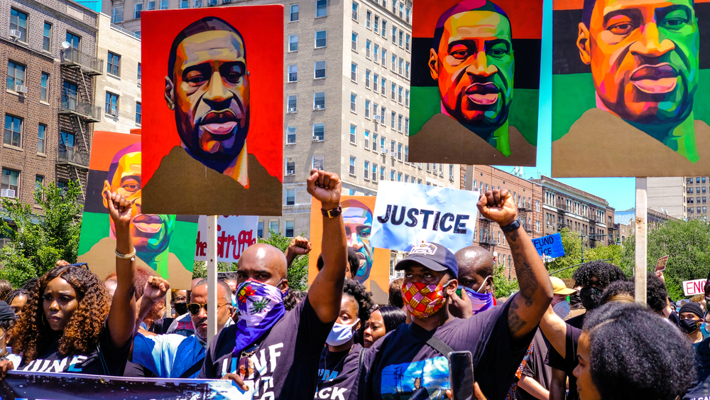 Marchers raise their fists at a justice rally for George Floyd and celebration of Juneteenth. Image by Fiora Watts / Shutterstock. United States, 2020. Marchers raise their fists at a justice rally for George Floyd and celebration of Juneteenth. Image by Fiora Watts / Shutterstock. United States, 2020.