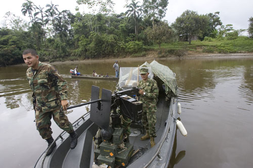 A navy officer walks over an armored Piraña boat used to fight guerrillas along the Tapaje river, Pueblo Nuevo, Colombia, July 8, 2007. Pueblo Nuevo, also known as Pulviza, was the scene of crude battles between the Colombian army and FARC guerrillas last April, leaving the town without a single resident. 1