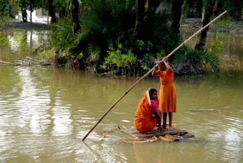 A young girl guides her mother and new-born sister back to their home, cut off by flooding. Media file: 1059.jpg