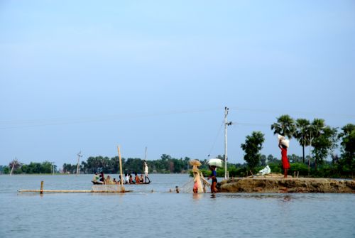 People fording water on foot in order to bring food back to their marooned village. Media file: 1060.jpg