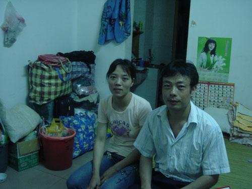 Yu Wanlin and his wife in their apartment in Shenzhen. Mr. Yu lost part of his index finger while making couches for America, a result of using primitive equipment while sawing. Image by Loretta Tofani. China, 2007. Media file: 1093.jpg