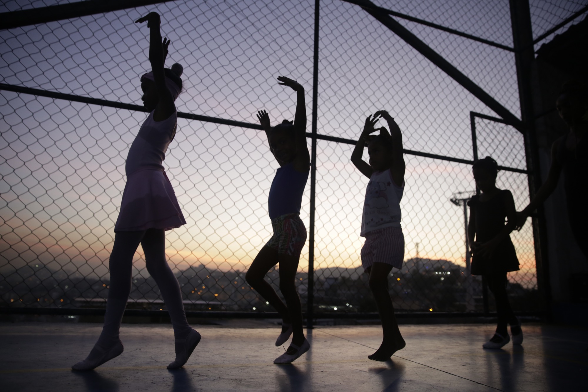 Young ballerinas rehearse at an outdoor sports court in the Morro do Adeus favela, Rio de Janeiro. Image by Frederick Bernas. Brazil, 2018. Young ballerinas rehearse at an outdoor sports court in the Morro do Adeus favela, Rio de Janeiro. Image by Frederick Bernas. Brazil, 2018.