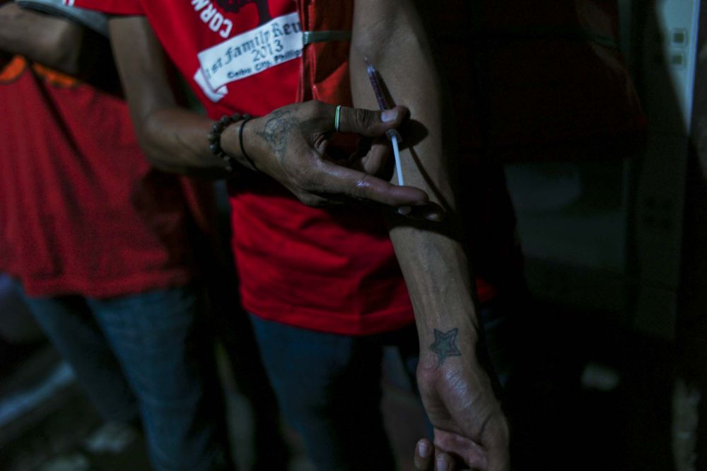 INJECTION. A drug user injects a mixture of Nubain, a narcotic painkiller. Even with the strict regulations, Nubain is common amongst 'shooters' because they can purchase it in increments as cheap as P20 ($.50). Image by Veejay Villafranca. Philippines, 2015. Media file: l1000192.jpg