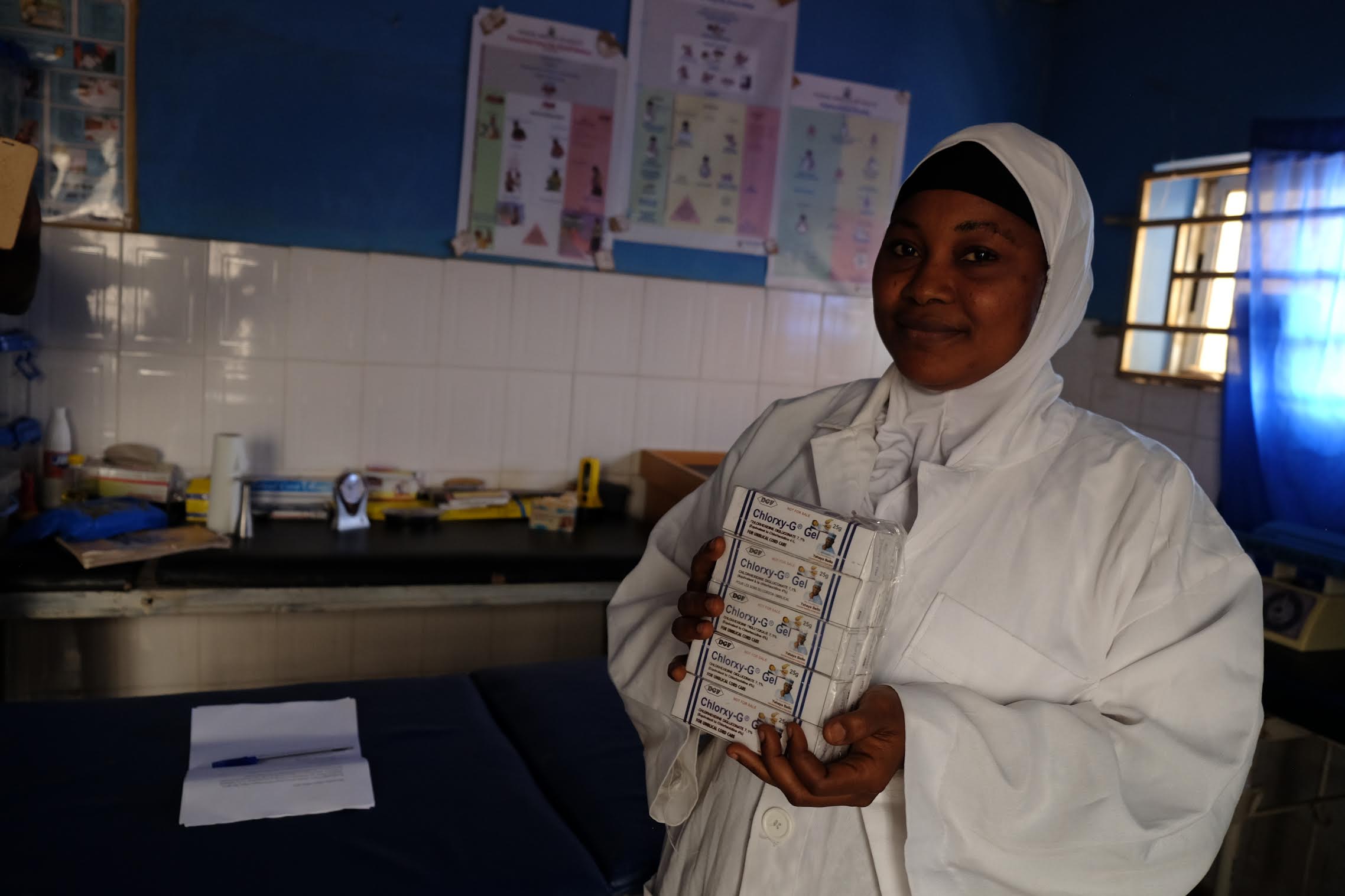 Fatima Yakubu, a Nigerian community health extension worker, holds tubes of chlorhexidine digluconate 7.1 percent gel. Yakubu’s rural primary health care facility is one of about 120 clinics in the central Nigerian state of Kogi that are supported by USAID’s Maternal and Child Survival Program. Image by T.R. Goldman. Nigeria, 2017. Fatima Yakubu, a Nigerian community health extension worker, holds tubes of chlorhexidine digluconate 7.1 percent gel. Yakubu’s rural primary health care facility is one of about 120 clinics in the central Nigerian state of Kogi that are supported by USAID’s Maternal and Child Survival Program. Image by T.R. Goldman. Nigeria, 2017.