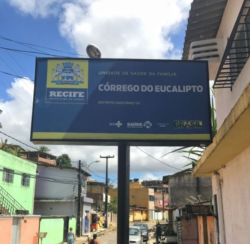 A placa indicado a entrada da Unidade de Saúde da Família (USF) no Córrego do Eucalipto. USFs são a peça chave na estratégia primaria do sistema de saúde público brasileiro. Foto por Poonam Daryani, Brasil, 2017. A placa indicado a entrada da Unidade de Saúde da Família (USF) no Córrego do Eucalipto. USFs são a peça chave na estratégia primaria do sistema de saúde público brasileiro. Foto por Poonam Daryani, Brasil, 2017.