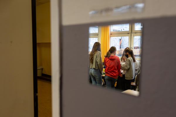 Students working on a book project at the Fritz-Karsen-Shule in Berlin are reflected in a mirror on the classroom wall. Image by Ryan Delaney. Germany, 2020. Students working on a book project at the Fritz-Karsen-Shule in Berlin are reflected in a mirror on the classroom wall. Image by Ryan Delaney. Germany, 2020.