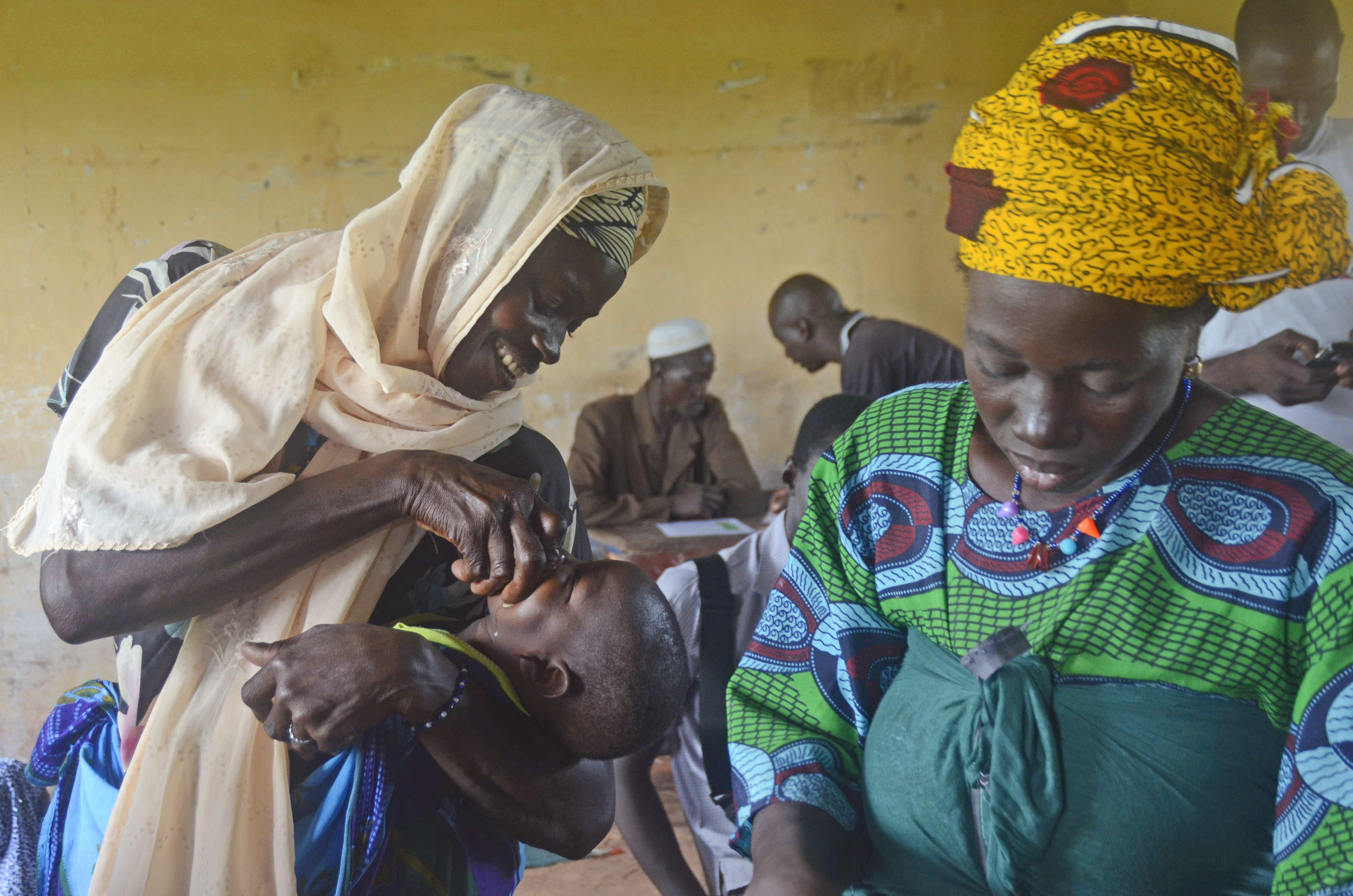 A mother gives her child malaria medicine to prevent the disease. Image by Amy Maxmen. Mali, 2013. Media file: _dsc2686.jpg
