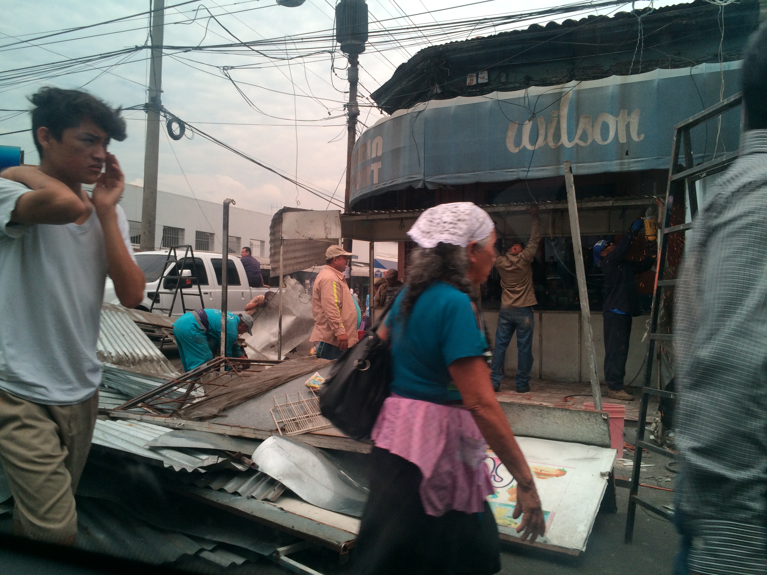 Municipal workers help dismantle the unauthorized market stalls in San Salvador's city center, much to the cheers of may San Salvadorans who feel that the congested market is bad for business, travel and safety, and to the fury of long-time vendors, who, as poor Salvadorans, don't trust that the options being offered to them will prove to improve their situation. Nayhib Bukele, however, insists that the new formalized market places he is planning will be a boon for the vendors. Image by Lauren Markham. El Salvador, 2016. Dismantling the Marketplace