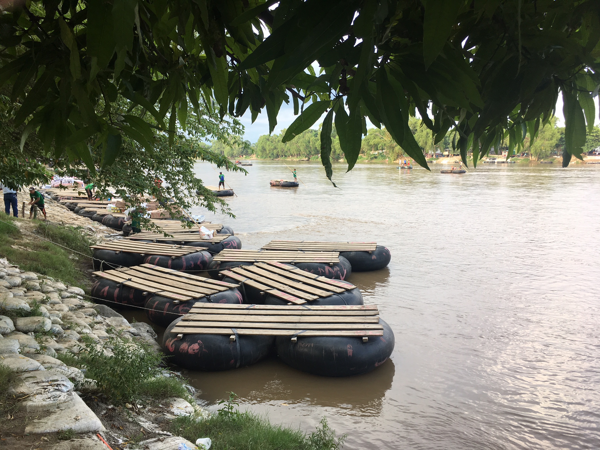 Rafts on the bank of the Suchiate River, which runs between Guatemala and Mexico. These rafts—largely ferrying market-goers and vendors—are also frequently used by U.S.-bound migrants crossing into Mexico. Image by Lauren Markham. Guatemala, 2018. Rafts on the bank of the Suchiate River, which runs between Guatemala and Mexico. These rafts—largely ferrying market-goers and vendors—are also frequently used by U.S.-bound migrants crossing into Mexico. Image by Lauren Markham. Guatemala, 2018.