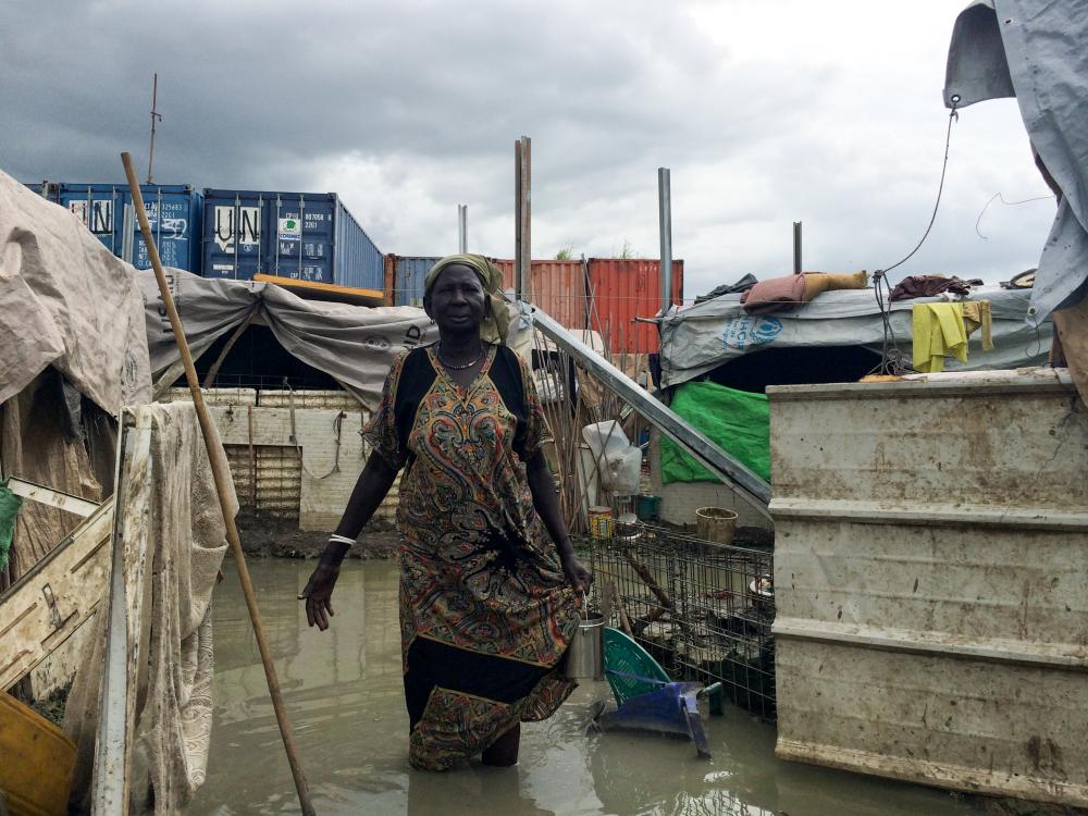 A woman stands in the flooded "protection of civilians" (POC) site on the U.N. base in Malakal, South Sudan. Thousands continue to live partially submerged in contaminated water. From the Pulitzer Center-supported project "When Militiamen Rule." Image by Ty McCormick. South Sudan, 2014. Media file: 1.jpg