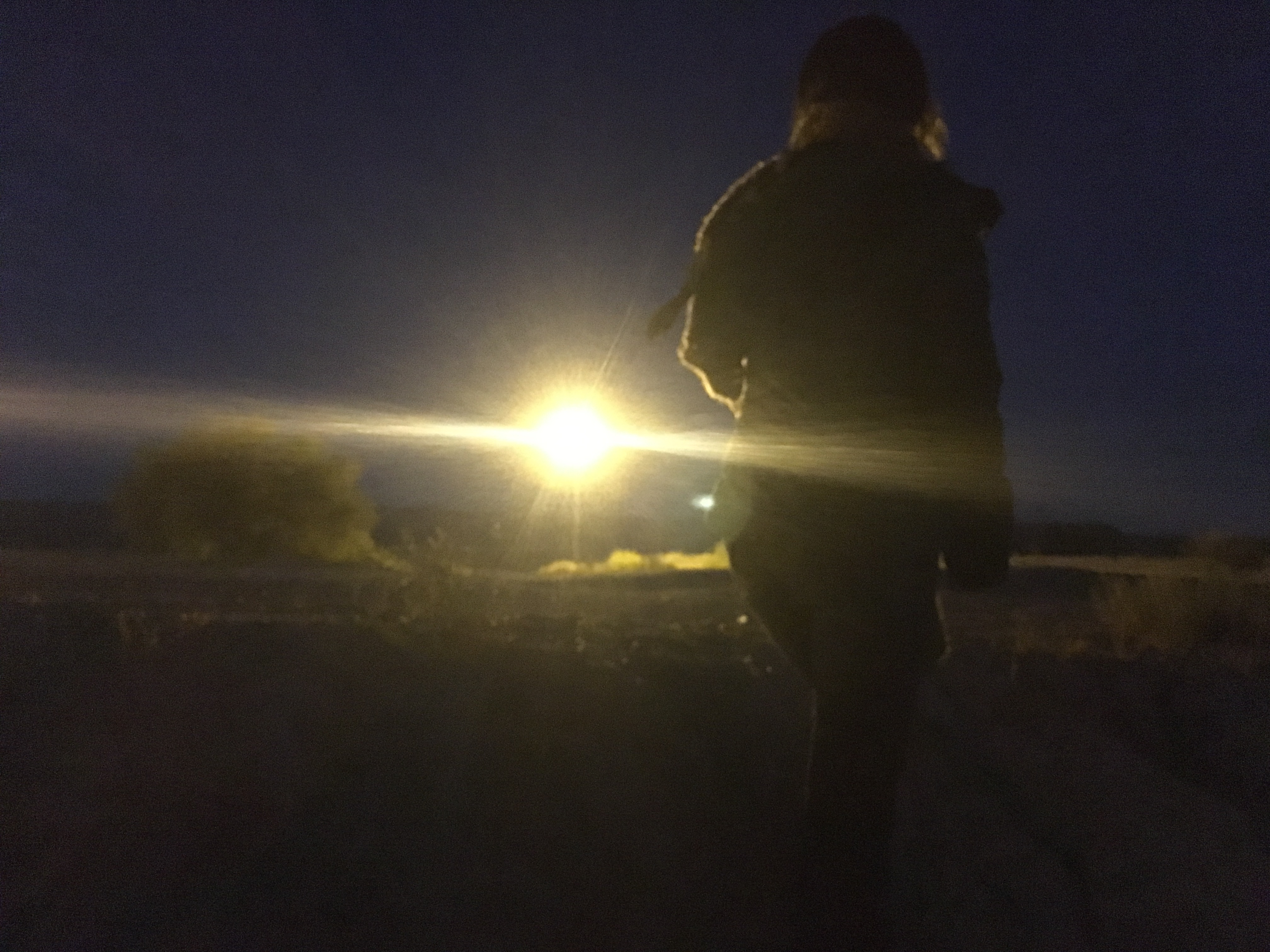 In the dry riverbed that separates Mexico from the United States, the promise of a better life is only a few hundred feet away. This woman is a 23-year-old Mexican from Ciudad Juarez who asked to remain anonymous. Everything beyond the flood light is El Paso, Texas, on the other side of the fence. She is trying to cross illegally. “There’s work here but the wages are very low,” she told us this past weekend. “You can barely survive here… Life there is better than here.” Image by Nicholas Schifrin. Mexico, 2016. In the dry riverbed that separates Mexico from the United States, the promise of a better life is only a few hundred feet away. This woman is a 23-year-old Mexican from Ciudad Juarez who asked to remain anonymous. Everything beyond the flood light is El Paso, Texas, on the other side of the fence. She is trying to cross illegally. “There’s work here but the wages are very low,” she told us this past weekend. “You can barely survive here… Life there is better than here.” Image by Nicholas Schifrin. Mexico, 2