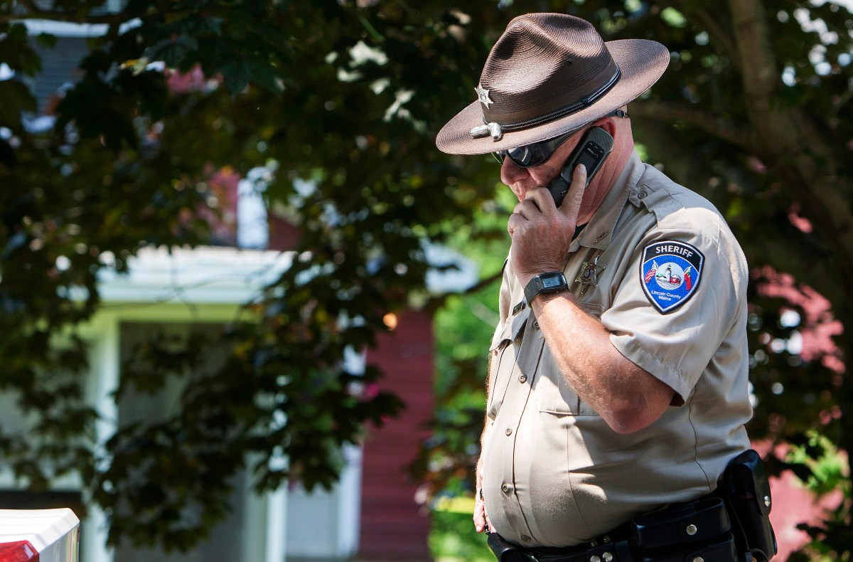 A deputy with the Lincoln County Sheriff's Office takes a phone call outside the scene of an investigation in Boothbay Harbor in this 2015 file photo. Image by Ashley L. Conti/BDN. United States, 2015. A deputy with the Lincoln County Sheriff's Office takes a phone call outside the scene of an investigation in Boothbay Harbor in this 2015 file photo. Image by Ashley L. Conti/BDN. United States, 2015.